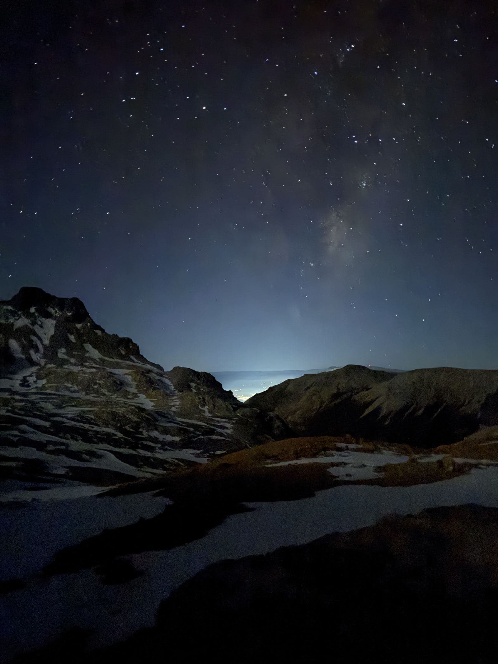 La luz de Coyhaique iluminando el cielo nocturno al fondo.